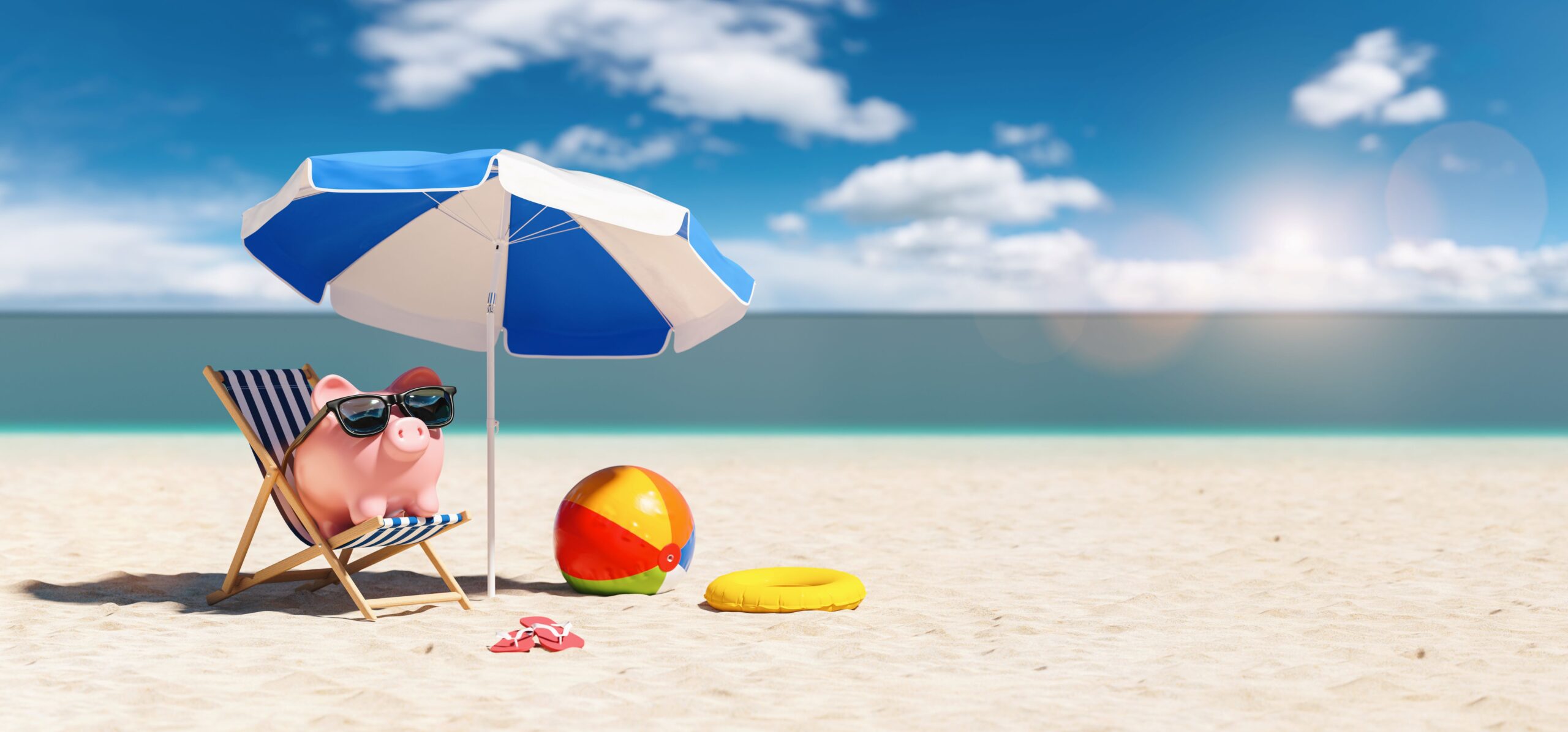 A piggy bank sits on the beach under an umbrella. 