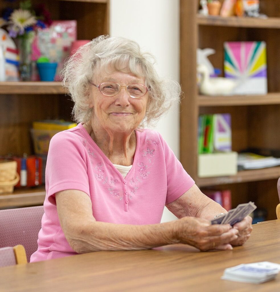 Senior citizen plays cards at Daybreak Adult Day Services 