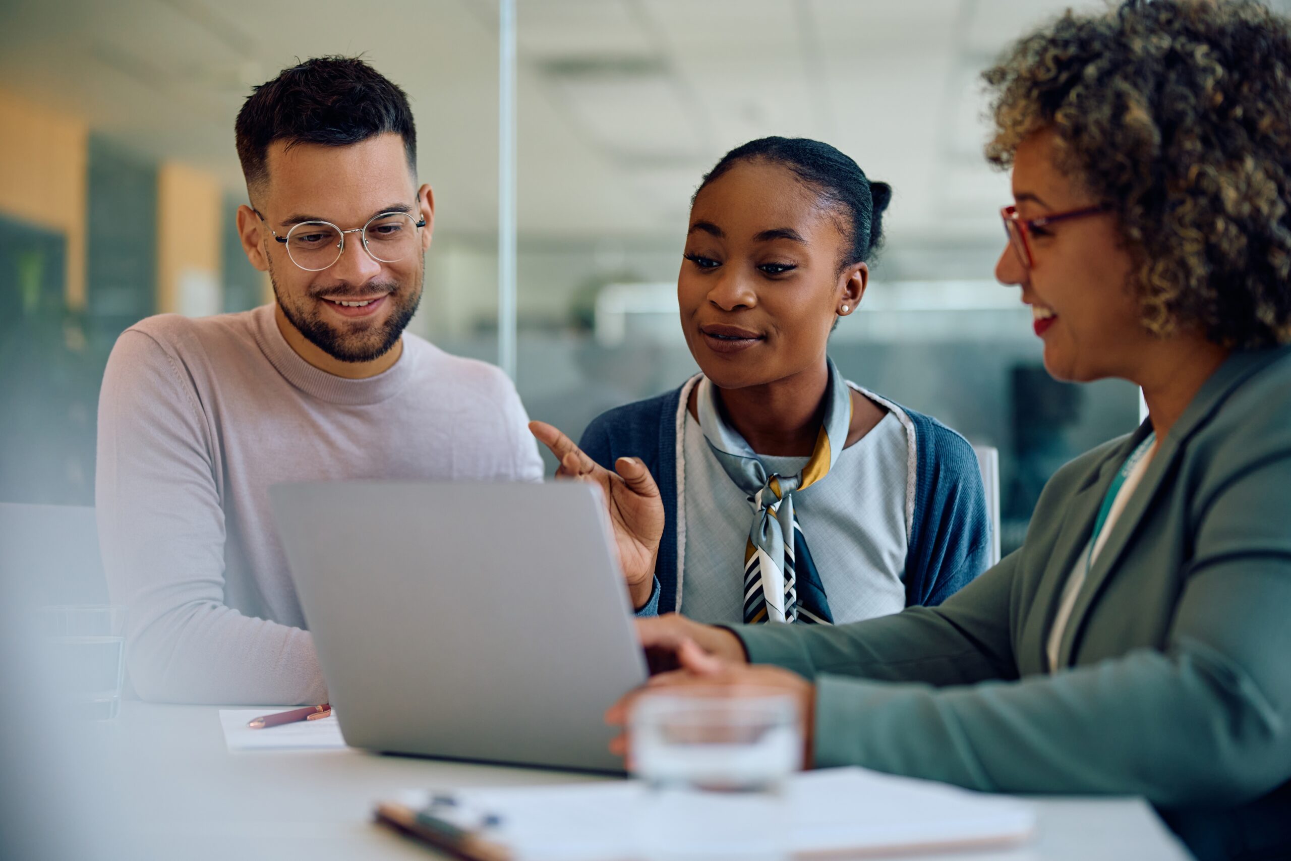 couple sits with an advisor looking at a laptop 