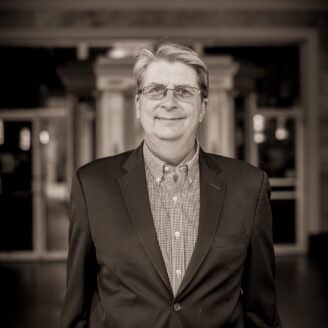 Black and white photo of John Healey standing outside The Weinberg Center