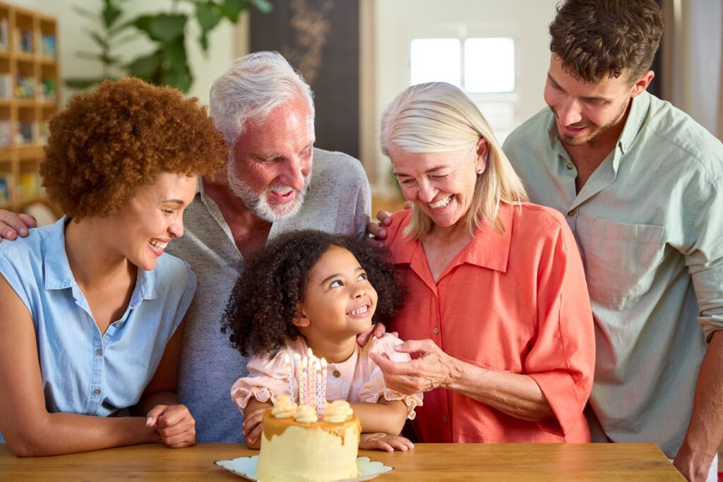 multigenerational family sitting in front of a cake