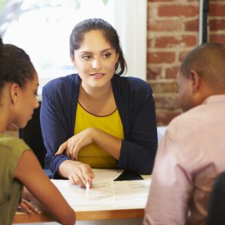 Couple Meeting With Financial Advisor In Office