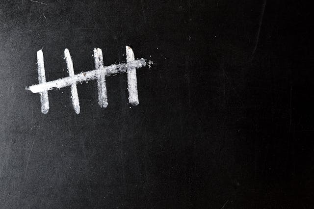 five white chalk tally marks on a black board